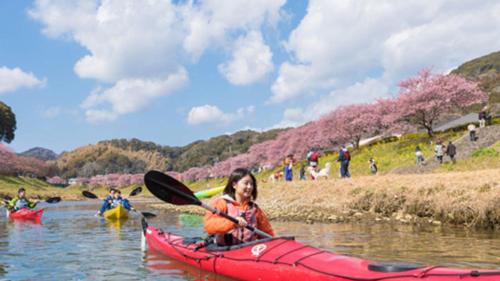 南伊豆町Kyukamura Minami-Izu的河上红皮艇上的女人