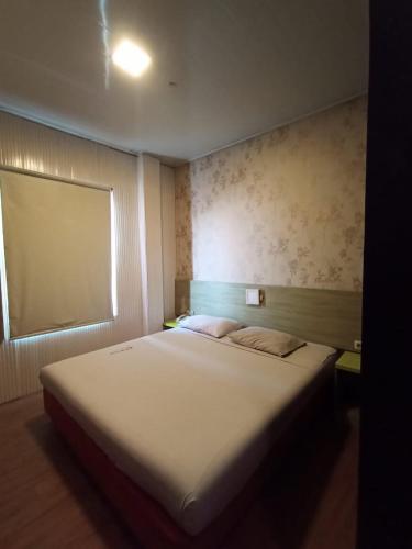 雅加达Hotel Aleander的卧室配有一张大白色床和窗户