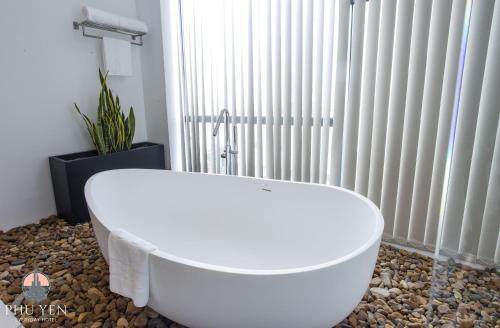 绥和市PHÚ YÊN EVERYDAY HOTEL的暖气旁浴室内的白色浴缸