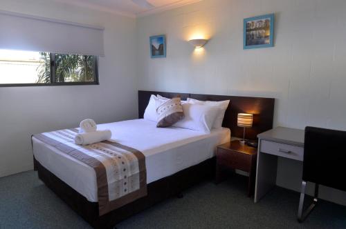 达尔文阿勒泰假日公寓酒店的酒店客房配有一张床、一张书桌和一张西德西德西德西德床