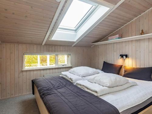 哈姆堡Three-Bedroom Holiday home in Hemmet 30的一间卧室配有一张带天窗的大床
