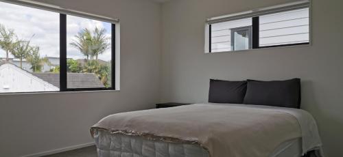 奥克兰Stunning Stay In Papatoetoe Auckland的一间卧室设有一张床和一个大窗户