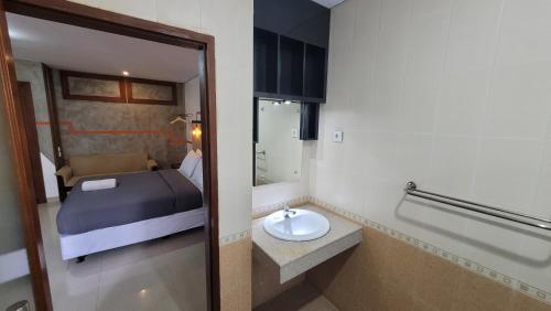 勒吉安雷根桑达玛斯酒店的客房内的浴室设有床和水槽