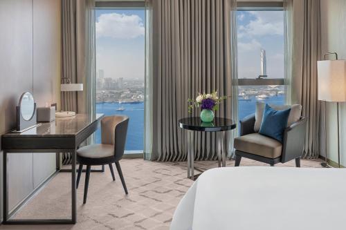 迪拜云溪港地标酒店的酒店客房设有一张桌子、椅子和大窗户。