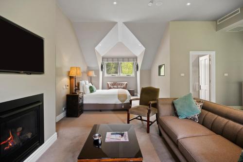 黑荒地Parklands Country Gardens & Lodges Blue Mountains的客厅配有沙发和1张床
