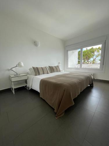 锡切斯Viva Sitges - Sitges View的白色的卧室设有一张大床和一个窗户