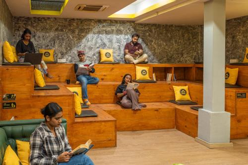 新德里The Hosteller Delhi的一群坐在房间长椅上的人