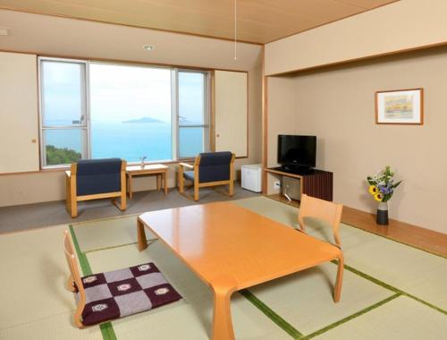 西条市Kyukamura Setouchi-Toyo的客厅配有桌椅