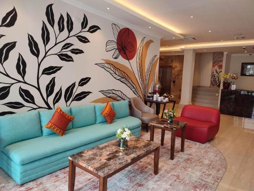 巨港Kesuma Front One Boutique Palembang的客厅配有蓝色的沙发和花卉壁画