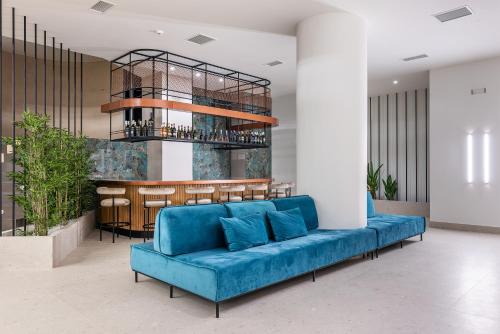 艾伊翁Amario Suites Hotel的带酒吧的房间里一张蓝色的沙发