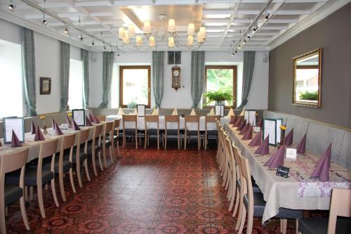 桑卡特弗洛里阿姆因圣弗洛里安酒店的宴会厅配有桌椅和吊灯