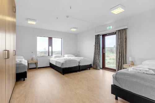 雷克雅未克Víðines Guesthouse的一间卧室设有两张床和大窗户