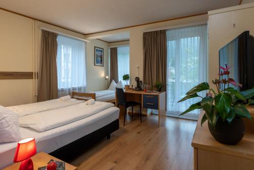 帕尔潘Grischalodge das Hotel mit Bergblick seit 1929的配有一张床和一张书桌的酒店客房
