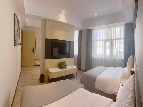 格尔木兰欧酒店格尔木八一中路的酒店客房设有两张床和一台平面电视。