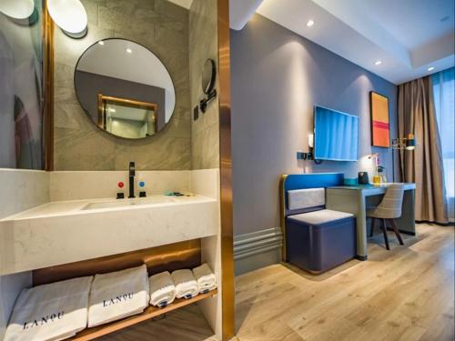 菏泽菏泽牡丹区大学城兰欧酒店的一间带水槽和镜子的浴室以及一张书桌