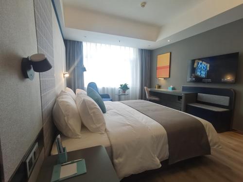 鹿泉兰欧酒店石家庄鹿泉动物园景区的酒店客房设有一张大床和一张书桌。