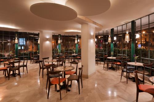 耶路撒冷普瑞玛国王酒店 的餐厅设有桌椅和窗户。