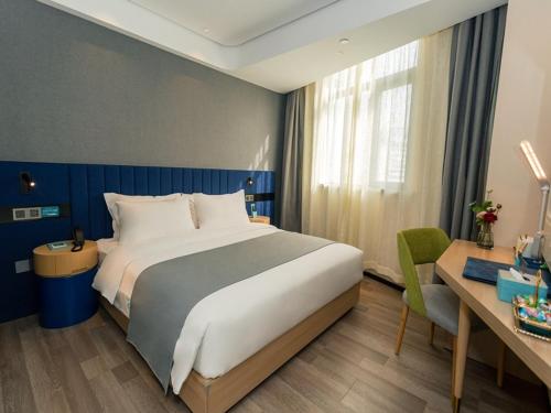 金湖淮安金湖苏宁广场健康西路兰欧尚品酒店的酒店客房设有一张大床和一张书桌。