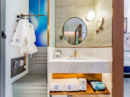呼和浩特呼和浩特新城区摩尔城兰欧尚品酒店的浴室配有盥洗盆、镜子和毛巾