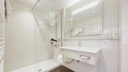 菲尔德施塔特Hotel Schwanen Stuttgart Airport/Messe的白色的浴室设有水槽和淋浴。