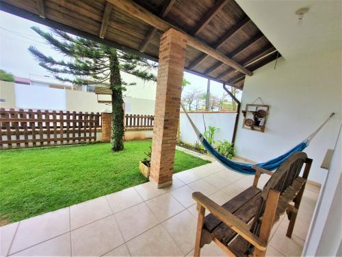 伊塔波阿Casa Conforto! A sua casa de praia em Itapoá - SC的享有庭院景致的客房内的吊床
