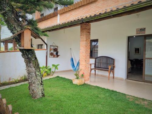 伊塔波阿Casa Conforto! A sua casa de praia em Itapoá - SC的一个带树、椅子和遮阳伞的庭院