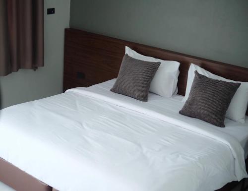YasothonThezen Hotel的一张带白色床单和枕头的床