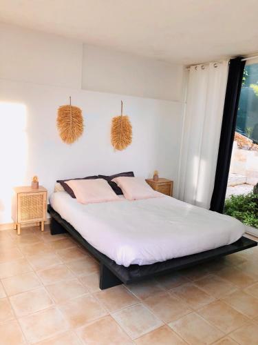 旺斯Chambre d’hôte vue mer的一间卧室配有带白色床单和粉红色枕头的床。