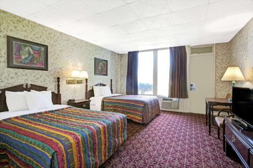 帕西帕尼帕西帕尼戴斯酒店的酒店客房设有两张床和电视。