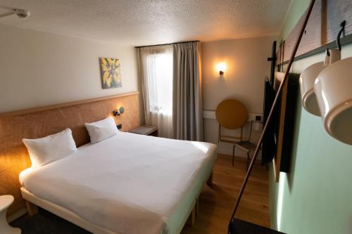 科尔马Greet Hotel Colmar的酒店客房设有白色的床和窗户。