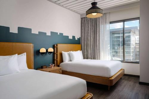奥斯汀Origin Austin, a Wyndham Hotel的酒店客房设有两张床和窗户。