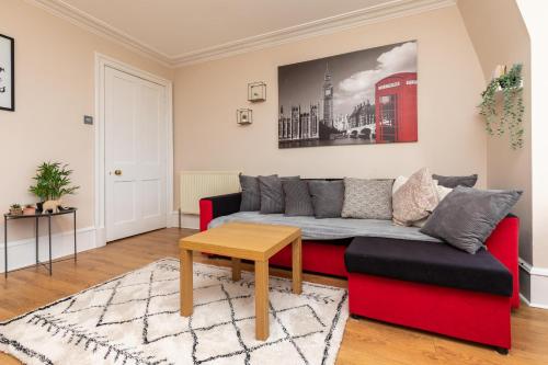 阿伯丁Modern Aberdeen City apartment free parking的客厅配有红色的沙发和桌子