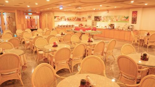 台南台南华都商务饭店的一间带桌椅的房间和一间自助餐厅