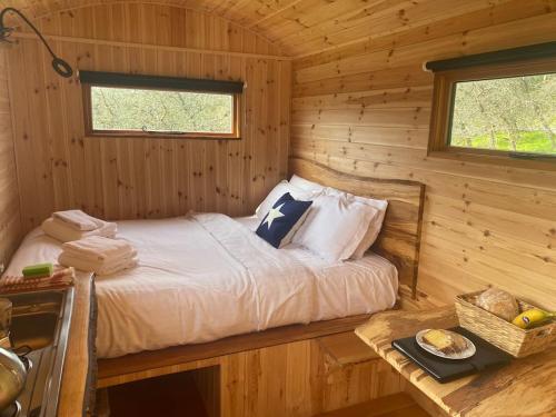 多切斯特Orchard retreat off grid shepherds huts in Dorset的小木屋内一间卧室,配有一张床