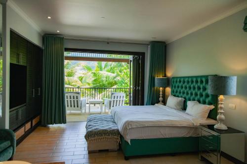 伊甸岛Maison La Plage by Simply-Seychelles的一间带大床的卧室和一个阳台