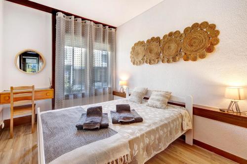 特罗亚Casa de Praia Tróia的一间卧室配有一张床,上面有两条毛巾