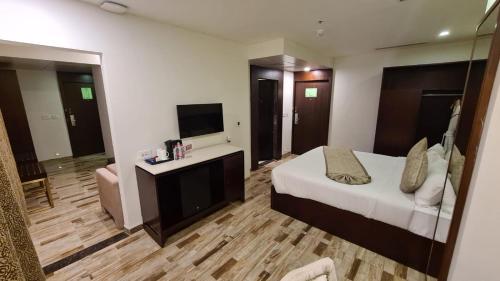 艾哈迈达巴德Regenta Inn Ranip Ahmedabad的酒店客房,配有床和电视