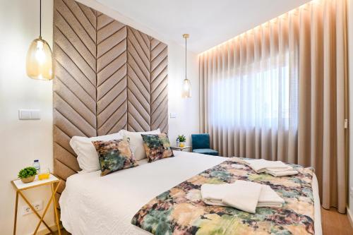 波尔图Lapa City Flat Porto - by Guest SPA的一间卧室设有一张大床和一个窗户。
