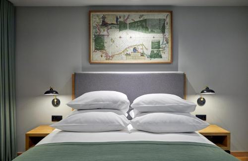 格但斯克格但斯克米亚斯托酒店的一张带白色枕头的床和一张墙上的照片