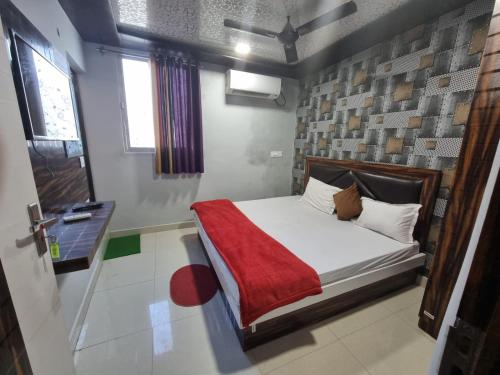戈勒克布尔Hotel Shanti Grand Inn的一间小卧室,配有一张带红色毯子的床