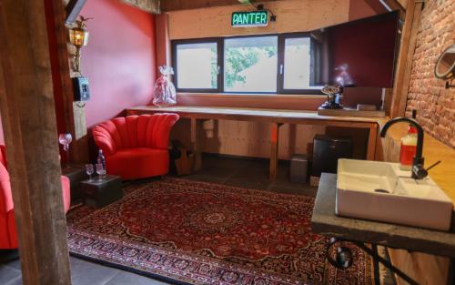 贝克VET - Bed & Breakfast的客厅配有红色椅子和水槽