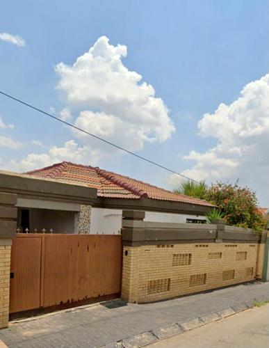 索韦托Colourful modern home的一座带木门和围栏的房子