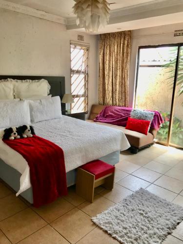 索韦托Colourful modern home的一间卧室配有一张带红色毯子的大床