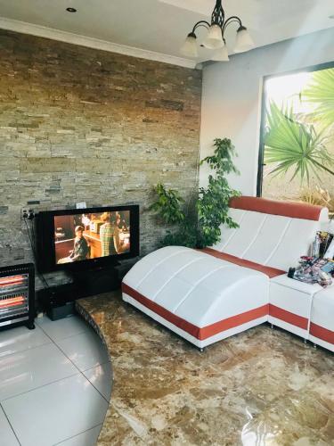索韦托Colourful modern home的一间卧室配有一张大床和一台平面电视