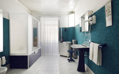曼泰加什科曼达多之家旅馆的蓝色的浴室设有水槽和卫生间