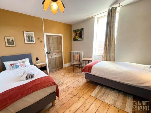克卢尼La Porte des Prés的一间卧室设有两张床和窗户。