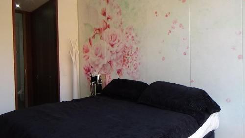 波哥大Hermoso Apartamento en el Norte 2 Habitaciones M52的卧室配有一张蓝色的床,墙上挂着鲜花