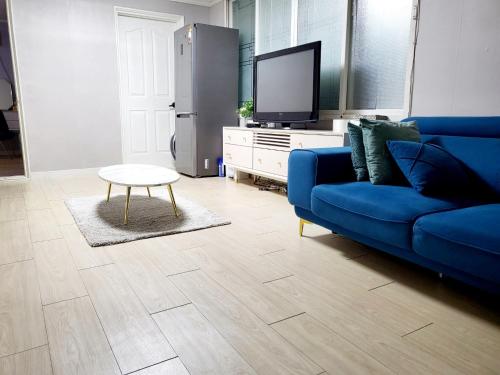 大邱Daegu Gyeong`s Hostel - Foreigner Only的客厅配有蓝色的沙发和电视