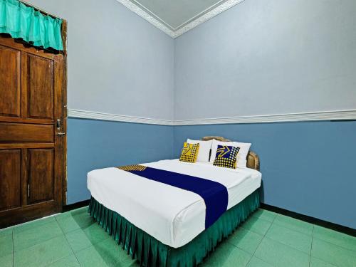 三宝垄SPOT ON 91912 Hotel Citra Dewi 2的蓝色客房中一间带床的卧室