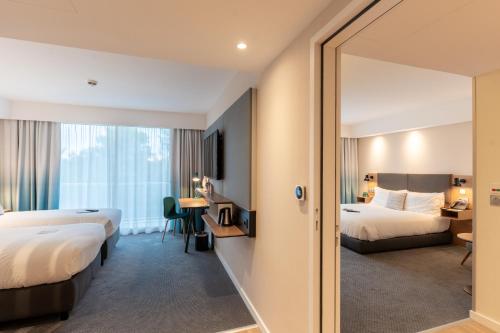 梅里尼亚克Holiday Inn - Bordeaux-Merignac, an IHG Hotel的酒店客房,设有两张床和镜子